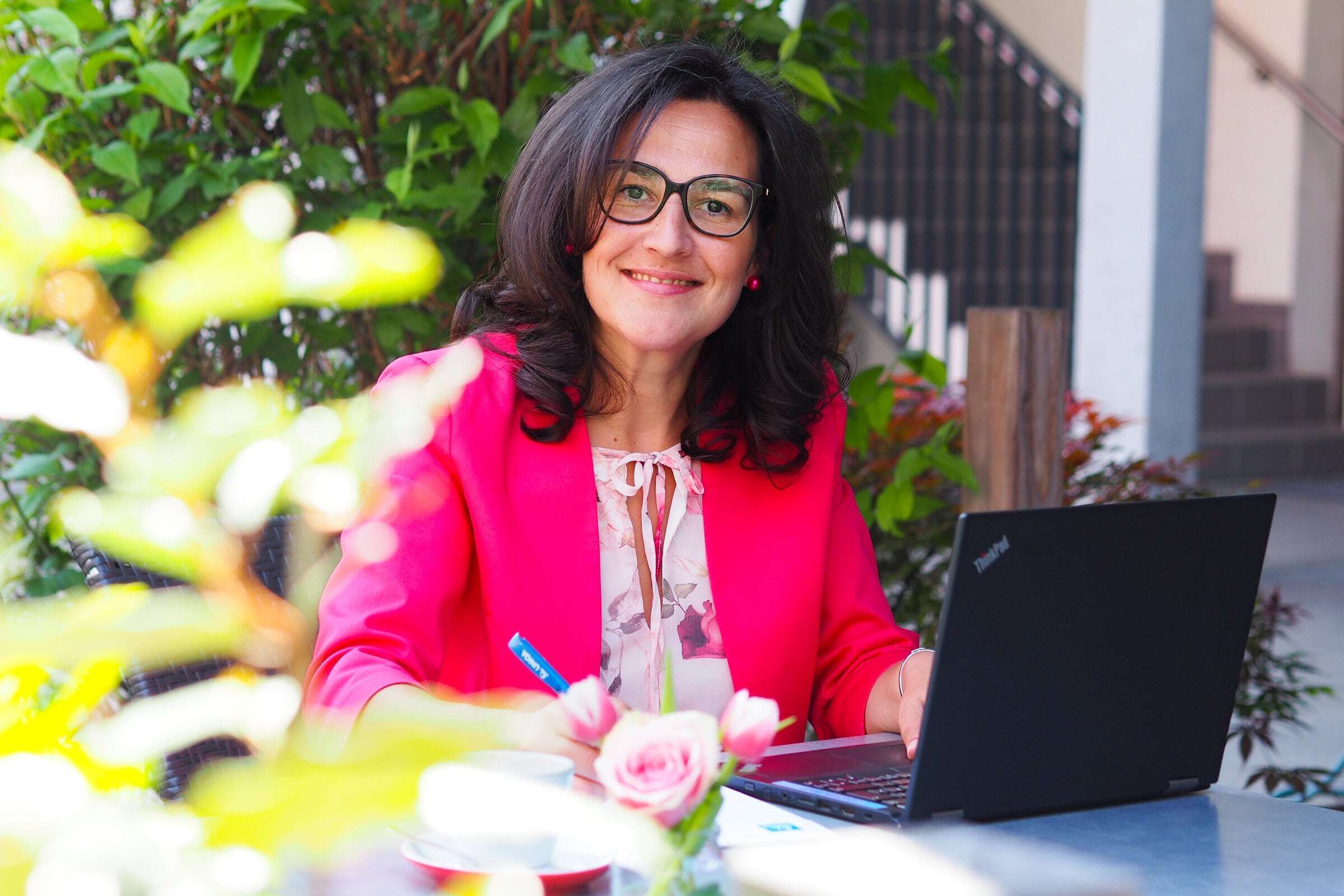 Die Versicherungsagentin Petra Winkler lächelnd vorm Laptop